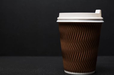 Siyah arka planda tek kullanımlık kahve fincanının yakın görüntüsü