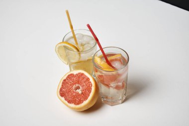 Beyaz masada pipetler ile limon ve greyfurt limonata iki bardak