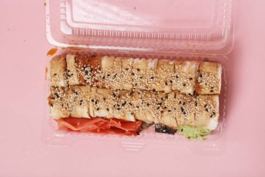 japon suşi ve pembe arka plan üzerinde rulo