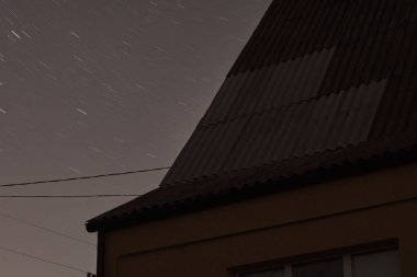 Düşük açılı bina manzarası ve görkemli karanlık yıldızlı gökyüzüne karşı kablolar