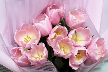 Çizgili pakete sarılmış pembe lale çiçekleri buketi
