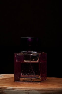 Ahşap koyu arka plan üzerinde şık parfüm şişesi