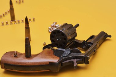 Parlak sarı arka planda mermi ile Silah