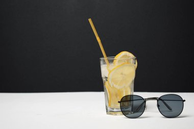 Beyaz masada saman ve güneş gözlüğü ile limonata Cam