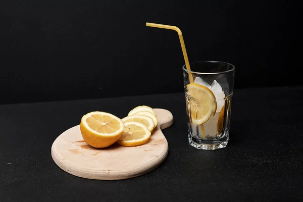 柠檬水果香 在木板上切成片的柠檬水果 有冰块和玻璃杯中的稻草 — 图库照片