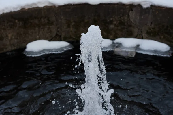 Closeup of small fountain splashing in winter park