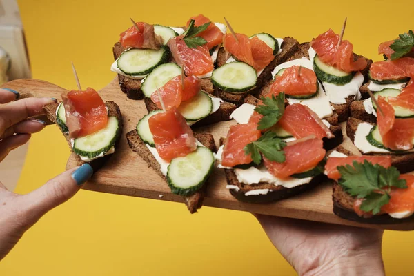 Mujer Sosteniendo Tablero Madera Con Sándwiches Salmón — Foto de Stock