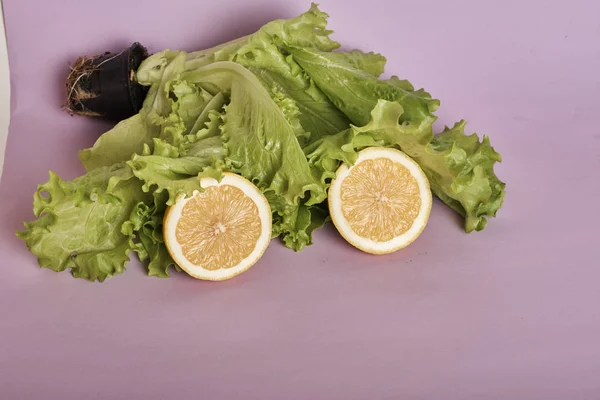 Nahaufnahme Von Frischen Zitronenscheiben Und Salatblättern Auf Violettem Hintergrund — Stockfoto