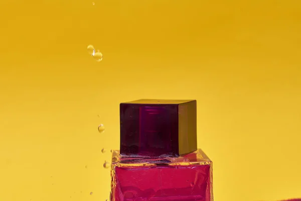黄色の背景に香水瓶のクローズアップビュー — ストック写真
