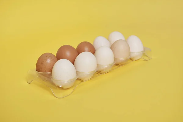 Telur Dalam Wadah Plastik Pada Latar Belakang Kuning Cerah — Stok Foto
