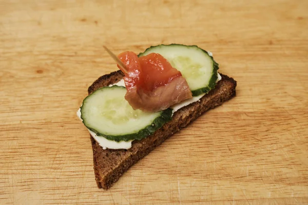 Salmon sandwich placed on wooden board