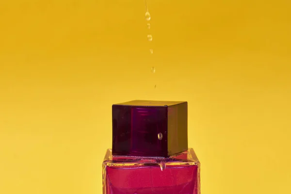 黄色の背景に香水瓶のクローズアップビュー — ストック写真