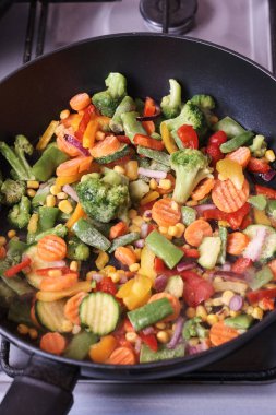 Kızartma tavasında lezzetli karışık donmuş sebzeler pişiriyorum.