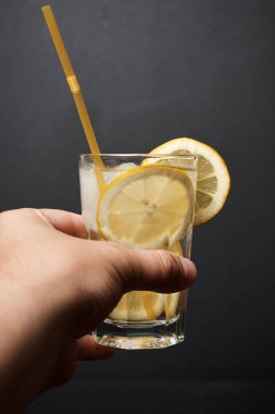 El ele tutuşup limon dilimli taze kokteyl, yakın görüş.
