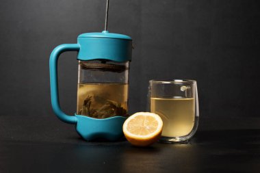 Siyah arkaplanda çaydanlık, cam ve limon yakın plan görüntüsü  