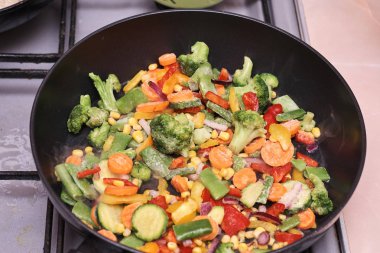 Kızartma tavasında lezzetli karışık donmuş sebzeler pişiriyorum.