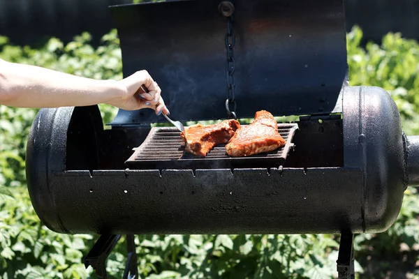 グリルで屋外で肉を焼く女性 バーベキュー — ストック写真