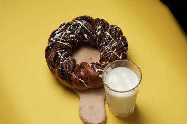 Fresh baked cake on wooden board served with glass of milk