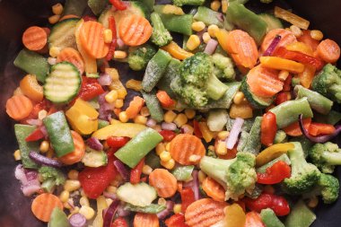 Kızartma tavasında lezzetli karışık donmuş sebzeler pişiriyorum.