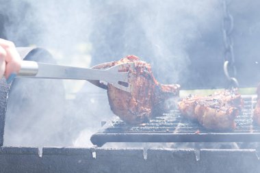 Kadın ızgarada et pişiriyor, barbekü yapıyor..