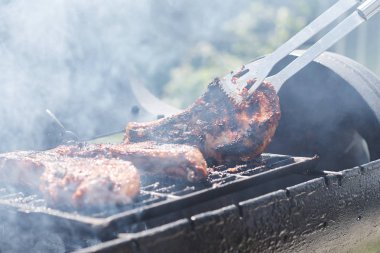 Kadın ızgarada et pişiriyor, barbekü yapıyor..