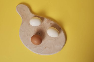 Tahtadaki yumurtalar parlak sarı arkaplanda.