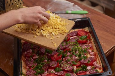 Şef peynir serpiyor, pizza üzerine peynir serpiştiriyor, yemek pişiriyor, elinde peynir tutan kadın, ev yapımı pizza..