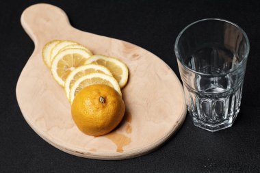 lemon slices on cutting board with empty glass, concept of preparing summer cocktail 