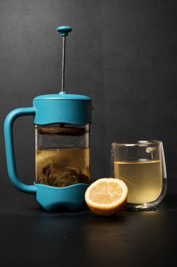 Siyah arkaplanda çaydanlık, cam ve limon yakın plan görüntüsü  