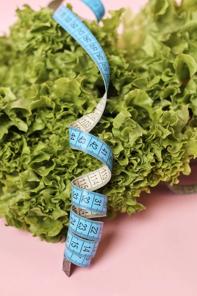 Verse Salade Bladeren Roze Achtergrond Met Meetlint Dieet Concept — Stockfoto