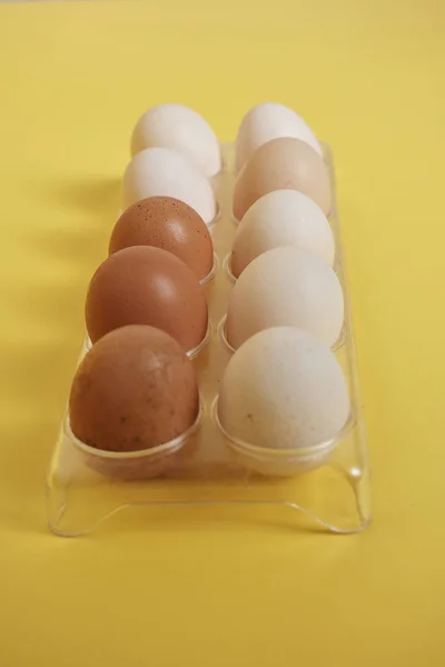Telur Dalam Wadah Plastik Pada Latar Belakang Kuning Cerah — Stok Foto