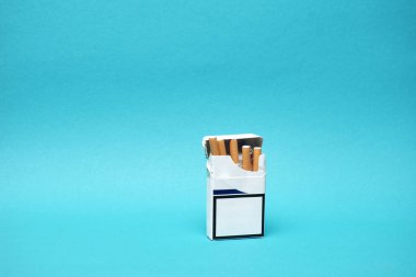 Mavi arkaplanda boş etiketli sigara paketlerinin yakın plan görüntüsü.