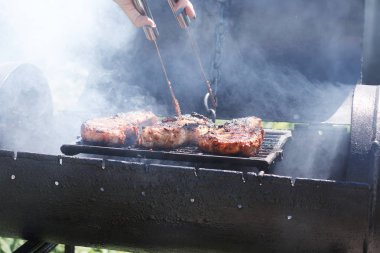Kadın ızgarada et pişiriyor, barbekü yapıyor..