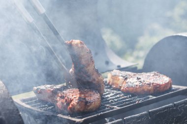 Kadın ızgarada et pişiriyor, barbekü yapıyor..