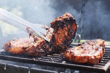 Kadın ızgarada et pişiriyor, barbekü yapıyor..