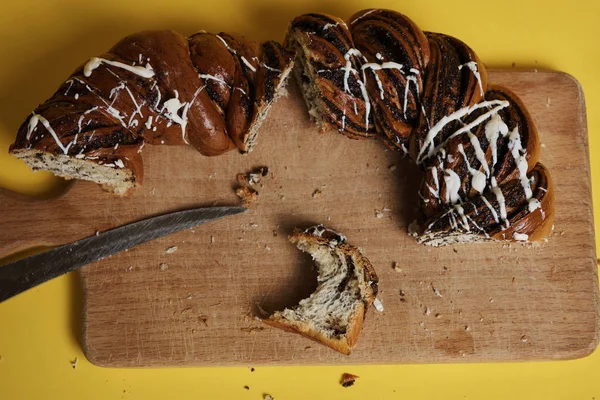 Woman cut fresh baked cake on wooden board with knife