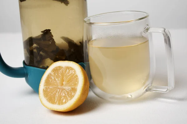 teapot, glass and lemon in white background