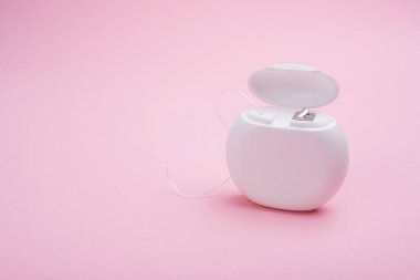 Pembe arka planda diş ipinin yakın plan görüntüsü. Boşluğu kopyala.