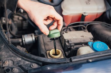 Tamirci vananın direksiyon sıvısını sıkıyor. Araba tamircisi direksiyon sıvısını değiştiriyor. Kesilmiş atış.