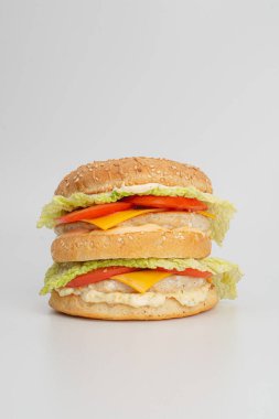 Beyaz arka planda peynirli ve sebzeli lezzetli sandviçin yakın plan görüntüsü.