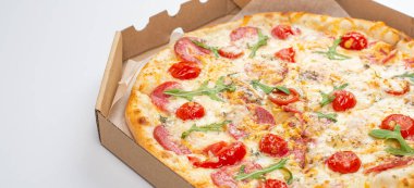 Beyaz arka planda domatesli, salamlı ve peynirli pizzanın yakın plan görüntüsü. 