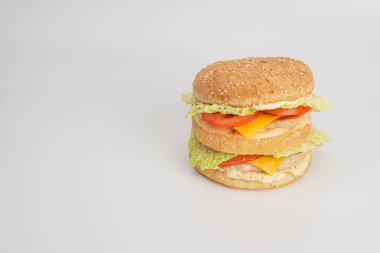 Beyaz arka planda peynirli ve sebzeli lezzetli sandviçin yakın plan görüntüsü.