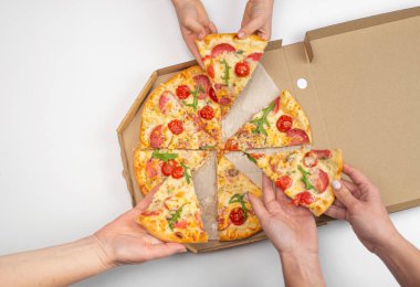 Beyaz arka planda ellerinde domatesli, salamlı ve peynirli pizza dilimleri olan insanlar.  