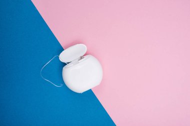 Mavi ve pembe arka planda diş ipinin yakın plan görüntüsü. Boşluğu kopyala.