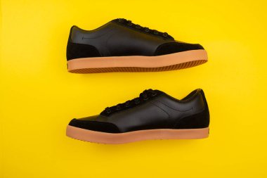 Yeni siyah erkek ayakkabılar. Sarı arka planda şık erkek ayakkabıları