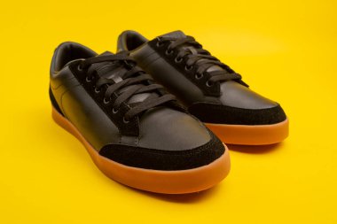 Yeni siyah erkek ayakkabılar. Sarı arka planda şık erkek ayakkabıları