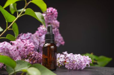 Parfüm şişesi ve çiçekler ahşap bir masada.