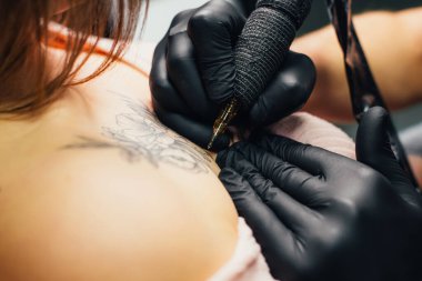 Professional artist making tattoo in salon, closeup clipart