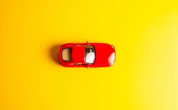 red toy car on yellow background