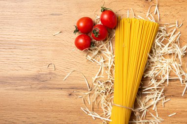 Ahşap arka planda domatesli pişmemiş spagetti manzarası.